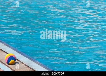 Pallina d'acqua colorata sul piedistallo della piscina con fuori di fuoco blu acqua con spazio di copia Foto Stock