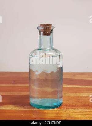 Bottiglia piena d'acqua su un tavolo di legno. Foto Stock