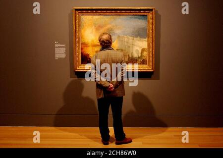 L'uomo non identificato guarda con orgoglio la mostra "The Burning of the Houses of Lords and Commons" di Turner Whistler Monet, che celebra tre dei grandi artisti europei del XIX secolo. Foto Stock