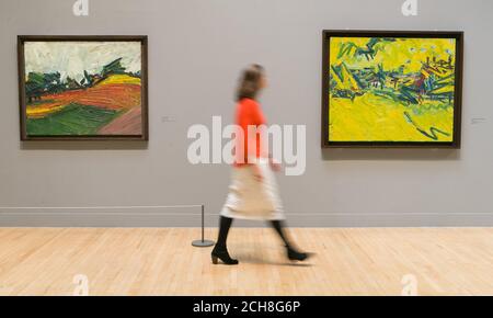 Un impiegato della galleria guarda un dipinto di Frank Auerbach chiamato 'l'origine del Grande Orso', 1967-8 (a destra), e Primrose Hill, 1971 (a sinistra), in una fotocellula per una nuova mostra dell'artista britannico al Tate Britain di Londra. Foto Stock