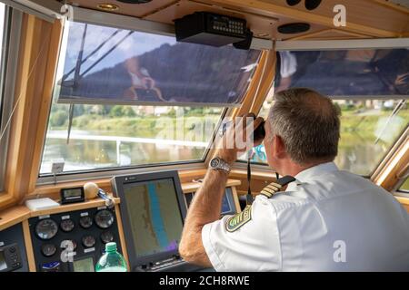 Pirna, Germania. 10 settembre 2020. Un poliziotto della polizia dell'acqua sta navigando sull'Elba vicino a Pirna in una grande barca di pattuglia chiamata Europa Patrol, guardando attraverso il binocolo. Durante la pattuglia, gli agenti di polizia a bordo della barca di polizia verificano che i partecipanti al traffico sulle acque federali si comportino correttamente e che nessuna persona stia nuotando in acqua o sia impotente. Credit: Daniel Schäfer/dpa-Zentralbild/ZB/dpa/Alamy Live News Foto Stock