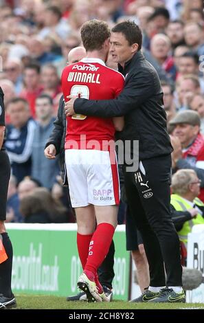 Sam Winnall di Barnsley abbracca Paul Heckingbottom (a destra), il direttore del custode di Barnsley, che viene sostituito dal campo durante il playoff Sky Bet League One, la prima partita a Oakwell, Barnsley. Foto Stock