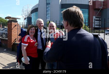 L'ex giocatore del Manchester United Paddy Crerand si pone per una foto con i tifosi fuori terra dopo un allarme di sicurezza prima della partita Barclays Premier League a Old Trafford, Manchester. Foto Stock