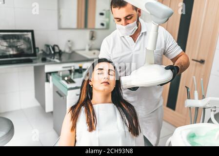 Dentista fare raggi x per il paziente di sesso femminile in clinica Foto Stock