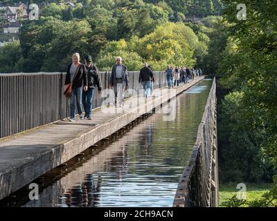 I pedoni attraversano l'acquedotto di Pontcysyllte, sito patrimonio dell'umanità del canale, che attraversa il fiume Dee vicino a Wrexham Galles del Nord Regno Unito Foto Stock