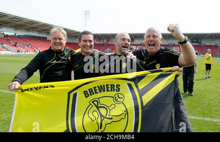 Nigel Clough, direttore di Burton Albion, e gli allenatori celebrano la promozione dopo la partita Sky Bet League One al Keepmoat Stadium, Doncaster. Foto Stock