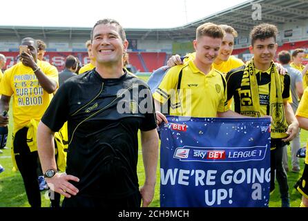 Nigel Clough, direttore di Burton Albion, e gli allenatori celebrano la promozione dopo la partita Sky Bet League One al Keepmoat Stadium, Doncaster. Foto Stock