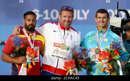 Daniel Greaves (centro) della Gran Bretagna con la sua medaglia d'oro dopo aver vinto l'evento maschile Discus durante il giorno uno dei Campionati europei di atletica 2016 allo Stadio Olimpico di Amsterdam. Foto Stock