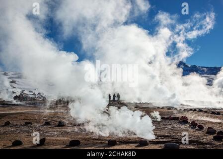 El Tatio geyser in Cile, sagome di turisti tra i vapori e fumarole di sunrise Foto Stock