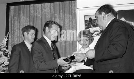 Il fotografo dello staff dell'associazione stampa George Stephenson (a sinistra, che riceve il premio) e il tecnico fotografico Brian McMillian (a sinistra) hanno ricevuto un assegno di £1,000 da Lord Goodman (r) a Sudbury House, Newgate Street, Londra. Il premio è stato assegnato all'immagine di Stephenson 'volo dagli incendi', una scena di strada azzurrata a Belfast che ha vinto il primo premio nella sezione news della categoria Stampa/Giornalismo del Concorso di stampa Ilford £1,000. Foto Stock