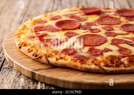 Pizza pepperoni italiana su tavolo di legno Foto Stock