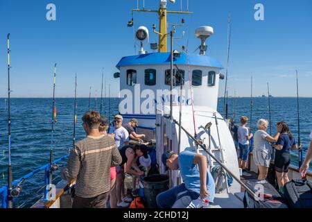 Malmo, Svezia - 6 agosto 2020: Persone in un viaggio di pesca in cerca di Codfish e sgombro. Oceano blu e cielo sullo sfondo Foto Stock