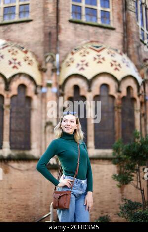 Caucasica cute ragazza in piedi vicino vecchio edificio in Europa. Foto Stock