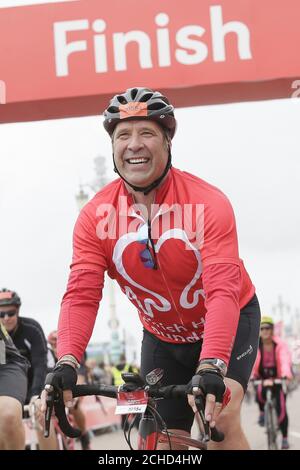 EDITORIAL USE ONLY David Seaman celebrates after finishing the British Heart Foundation's London to Brighton Bike Ride 2018. PRESS ASSOCIATION. Photo. Picture date: Sunday June 17, 2018. David joined 16,000 cyclists this year, helping raise around £3million for the charity's life-saving research. Heart and circulatory disease is responsible for around 150,000 deaths each year. Photo credit should read: Tim Ireland/PA Wire Foto Stock