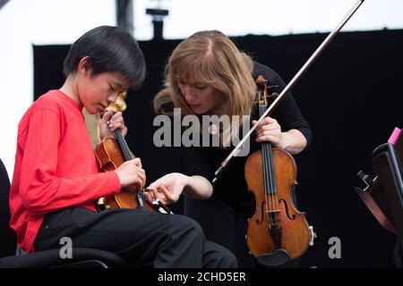 SOLO PER USO EDITORIALE Sir Simon Rpicle dirige la London Symphony Orchestra con 50 musicisti LSO sulla pista da tutta la East London e i musicisti della Guildhall School alla BMW Classics a Trafalgar Square, Londra. Foto Stock