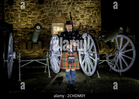 Piper Darren Robinson della Killadeas Pipe Band suona durante una cerimonia del giorno dell'armistizio all'alba al castello di Enniskillen a Co Fermanagh, Irlanda del Nord, nel centesimo anniversario della firma dell'armistizio che ha segnato la fine della prima guerra mondiale. Foto Stock