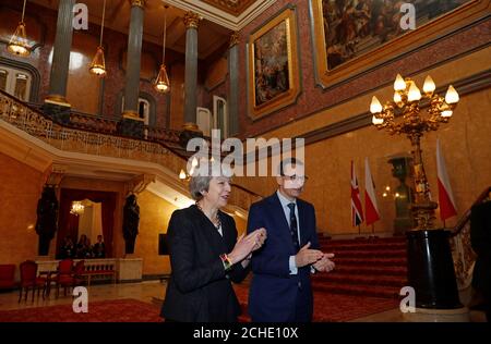 Il primo ministro Theresa May e il primo ministro polacco Mateusz Morawiecki applaudono dopo aver sentito un coro cantare durante le consultazioni intergovernative tra Regno Unito e Polonia a Lancaster House, Londra. Foto Stock