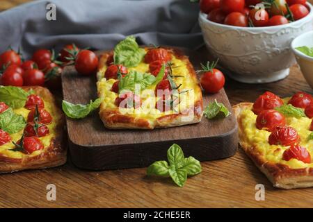 Crostata di pomodoro fresco, pasta sfoglia ricoperta di ricotta, formaggio e pomodori ciliegini Foto Stock