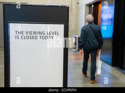 Un membro del pubblico passa accanto a un cartello chiuso nella galleria d'arte Tate Modern di Londra, dopo l'arresto di un maschio di 17 anni sospettato di tentato omicidio dopo che un ragazzo di sei anni è stato gettato dalla piattaforma di osservazione al decimo piano di domenica. Foto Stock