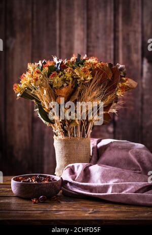 Bouquet di fiori secchi d'autunno su un tavolo rustico in legno e sfondo Foto Stock