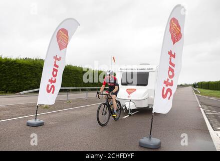 IMBARCATO AL 0001 LUNEDI 7 OTTOBRE EDITORIALE USO SOLO l'atleta di Endurance Mark Beaumont dimostra quanto velocemente può rimorchiare una carovana con una bicicletta davanti al Motorhome e Caravan Show, che inizia dal 15 ottobre al NEC Birmingham. Foto Stock