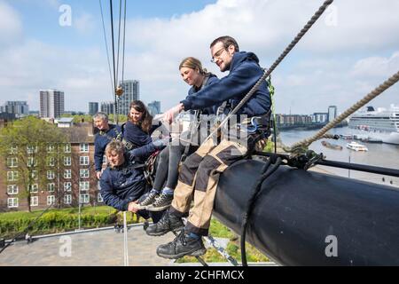 Il capo Riggers Chris Wood (a destra) e il suo team intraprendono lavori di manutenzione sui montanti da 152 piedi del Cutty Sark mentre si preparano per le navi 150 ° anniversario il mese prossimo, a Greenwich, Londra. Foto Stock