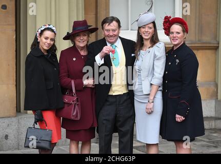 Nicky Henderson con la sua OBE, con la moglie Sophie (seconda a sinistra) e le figlie (da sinistra) Camilla, Tessa e Sarah, dopo una cerimonia di investitura a Buckingham Palace, Londra. Foto Stock