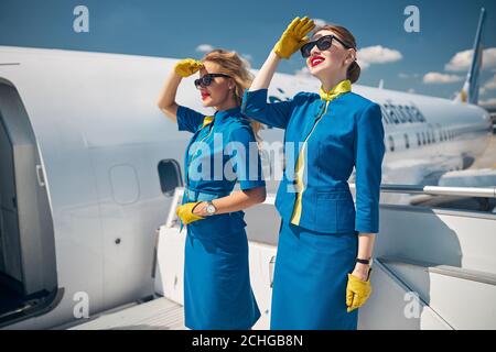 Due giovani donne che si levano in piedi sulle scale dell'aeroplano Foto Stock