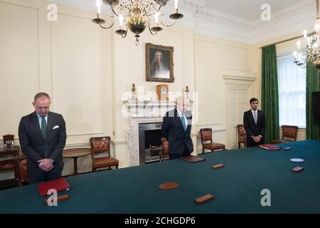 (Da sinistra a destra ) il Segretario di Gabinetto Mark Sedwill, il primo ministro Boris Johnson e il Cancelliere dello scacchiere Rishi Sunak, si trovano all'interno di 10 Downing Street, Londra, per osservare un minuto di silenzio in omaggio al personale dell'NHS e ai principali lavoratori morti durante l'epidemia di coronavirus. Foto Stock