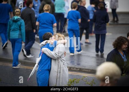 Il personale dell'NHS si consolò e si consolò a vicenda dopo che il corteo funebre dell'operaio dell'NHS Jane Murphy passò il reparto di emergenza e incidente all'Infirmary reale di Edimburgo, Edimburgo. Foto Stock