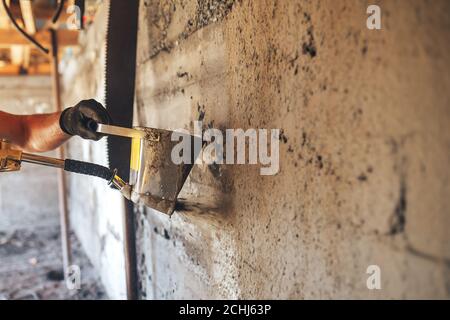 Uomo intonacando una parete con Malta usando un secchio di tramoggia Foto Stock