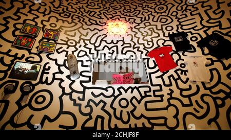 Un membro del personale all'interno di una ricreazione del tardo artista Keith Haring 'Pop Shop' - che ha aperto a New York nel 1986 per vendere articoli di marca con la sua firma artistica - durante un'anteprima stampa della mostra Pop Life: Art in a Material World, al Tate Modern di Londra. Foto Stock