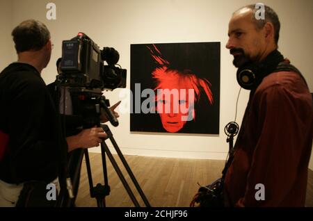 Membri dei media in una sala con opere d'arte di Andy Warhol, durante un'anteprima stampa della mostra Pop Life: Art in a Material World, al Tate Modern di Londra. PREMERE ASSOCIAZIONE foto. Data immagine: Martedì 29 settembre 2009. La mostra esamina i modi in cui gli artisti hanno costruito personae e marchi per se stessi fin dagli anni '80. Guarda per PA storia ARTS Pop. Il credito fotografico dovrebbe essere: Filo Yui Mok/PA Foto Stock