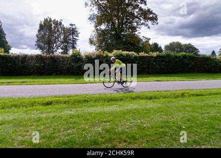 Un ciclista maschile di mezza età che corre su una strada di campagna Nelle colline di Surrey vicino Dorking Surrey Inghilterra UK Foto Stock