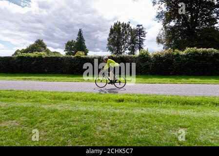 Un ciclista maschile di mezza età che corre su una strada di campagna Nelle colline di Surrey vicino Dorking Surrey Inghilterra UK Foto Stock