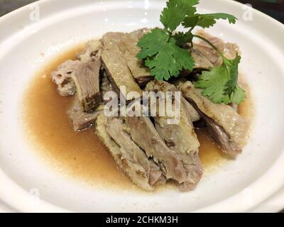 carne di oca brasata fresca con verdure verdi sul bianco piastra Foto Stock