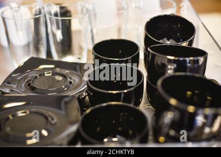 Le tazze da tè e i piatti neri sono posti sul tavolo per essere serviti. Foto Stock