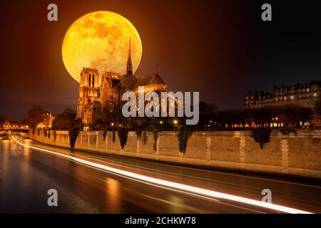 Luna sopra la cattedrale di Notre Dame prima di bruciare le navi Sentieri sull'acqua di notte a Parigi Foto Stock