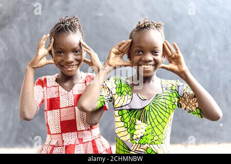 Divertirsi giocando con i gesti delle mani. Bei bambini africani di etnia nera che posano per la macchina fotografica Foto Stock