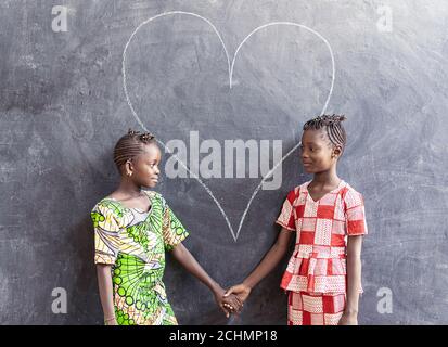 Splendide Black African cute Girls che si pongono insieme guardando sorridente Foto Stock