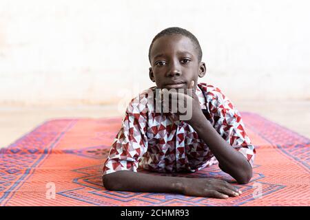 Black African Ethnicity Boy in posa come un modello sdraiato Su mat Foto Stock