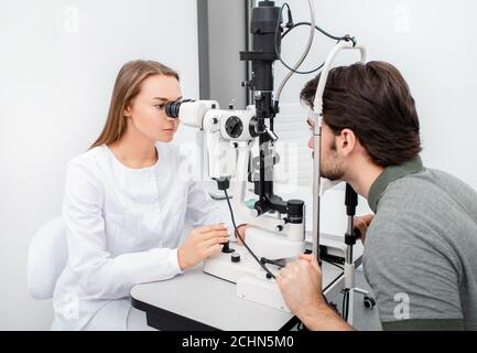 La donna del medico dell'occhio sta facendo un uomo adulto di esame diagnostico della vista. Concetto di cura degli occhi. Correzione della visione Foto Stock