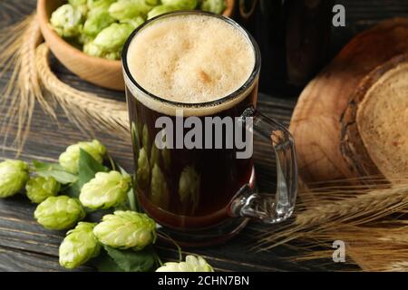 Birra, luppolo e grano su un tavolo di legno Foto Stock