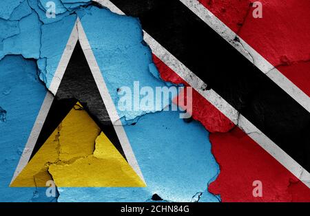 Bandiere di Santa Lucia e Trinidad e Tobago dipinte parete incrinata Foto Stock