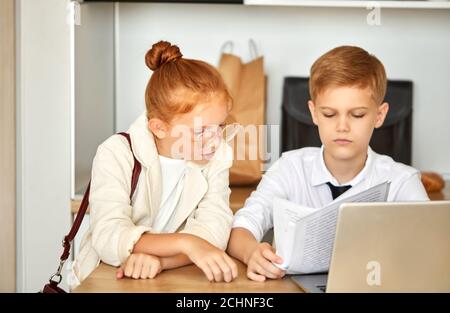 bella coppia caucasica bambini lavorano su laptop insieme, risolvere problemi di famiglia, pagare le bollette online, parlare. a casa, si comportano come annuncio Foto Stock