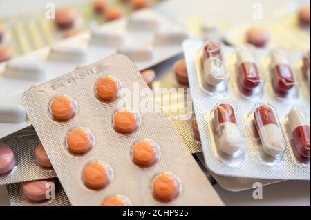 Chiusura di una pila di confezioni blister con varie compresse e pillole di medicinali. Foto Stock