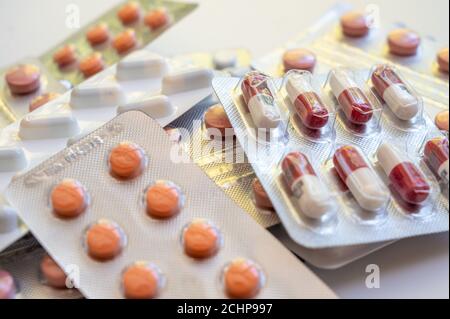 Chiusura di una pila di confezioni blister con varie compresse e pillole di medicinali. Foto Stock