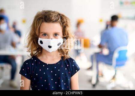 Ritratto di bambino con maschera facciale, coronavirus, covid-19 e concetto di vaccinazione. Foto Stock