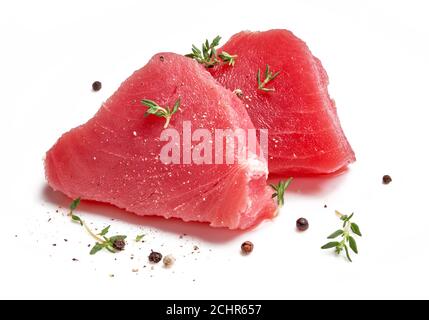 Due fette di carne di tonno cruda con erbe di timo e spezie isolate su sfondo bianco. Foto Stock