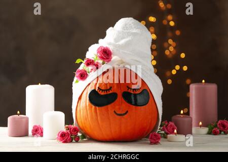 Candele e zucca con macchie sugli occhi su sfondo marrone Foto Stock